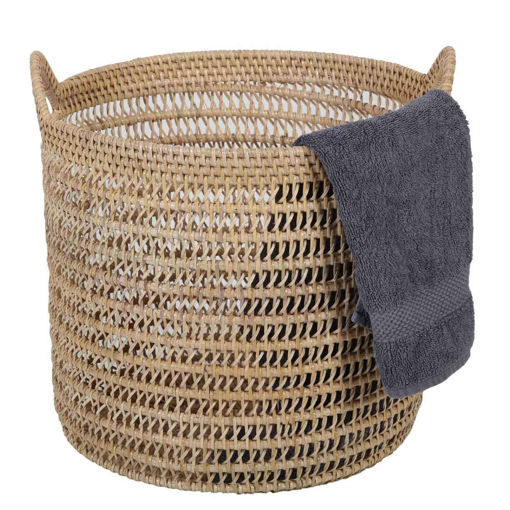 Naturelkleurige rotan mand Eda met open vlechtwerk, twee hengsels en een donkergrijze handdoek over de rand.