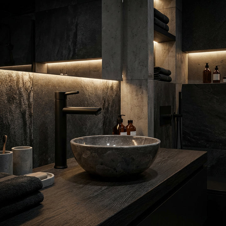 Lavabo en marbre à comptoir rond sur vanité en bois sombre dans une salle de bains spa moderne avec robinet noir et lumière indirecte