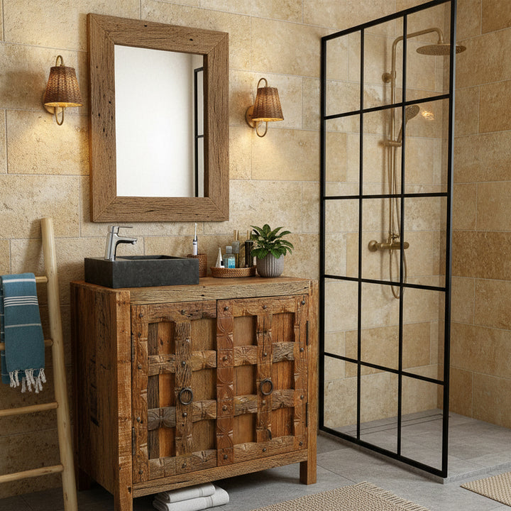 Hoekig Wastafel Gemaakt van steen met een donker oppervlak op een rustieke houten wastafel in de warme badkamer, gecombineerd met verchroomd beslag, een houten spiegel en een zwarte douchewand