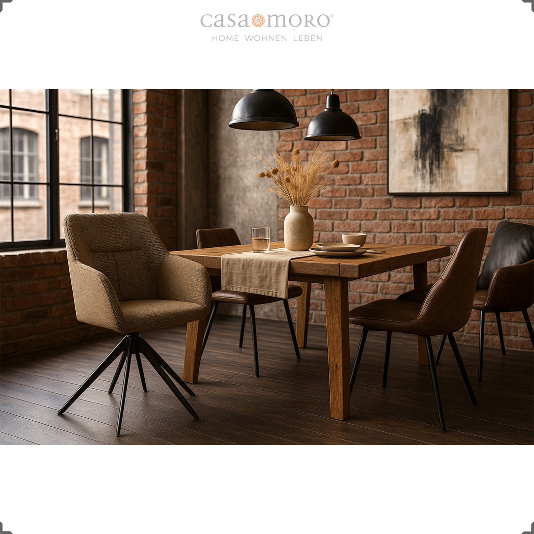 Chaise rembourrée rotative à 360° avec accoudoirs marron sur une table en bois dans une salle à manger moderne avec un mur de briques et des suspensions noires