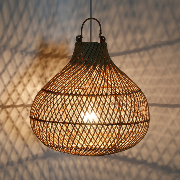 Plafonnier fait main en rotin avec un jeu de lumière chaleureux sur le mur, créant une atmosphère chaleureuse