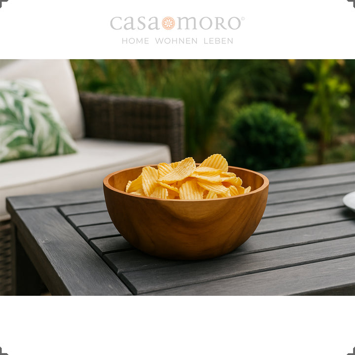 Decoratieve schaal met chips op een donkere tuintafel