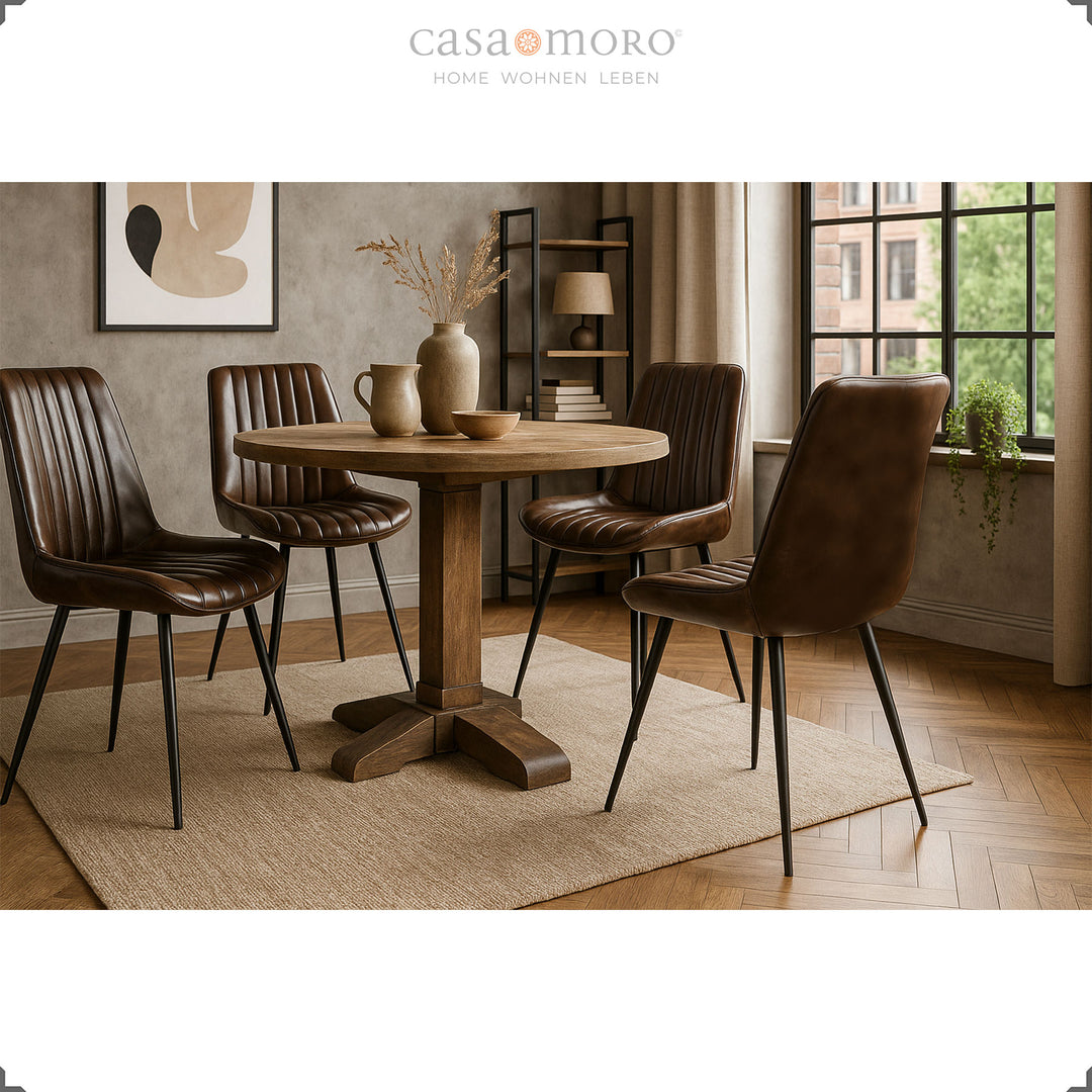 Vier antieke bruin lederen eetkamerstoelen rond een ronde houten tafel, stijlvolle woonkamer in warm licht