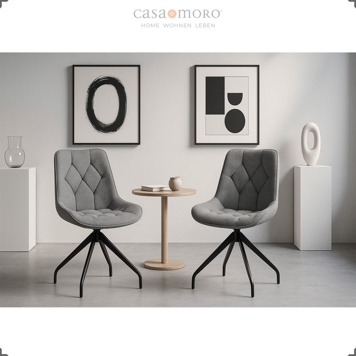 Deux chaises de salle à manger grises avec fonction pivotante à 360° et structure en métal noir - coin salon moderne avec table d'appoint et décoration murale minimaliste