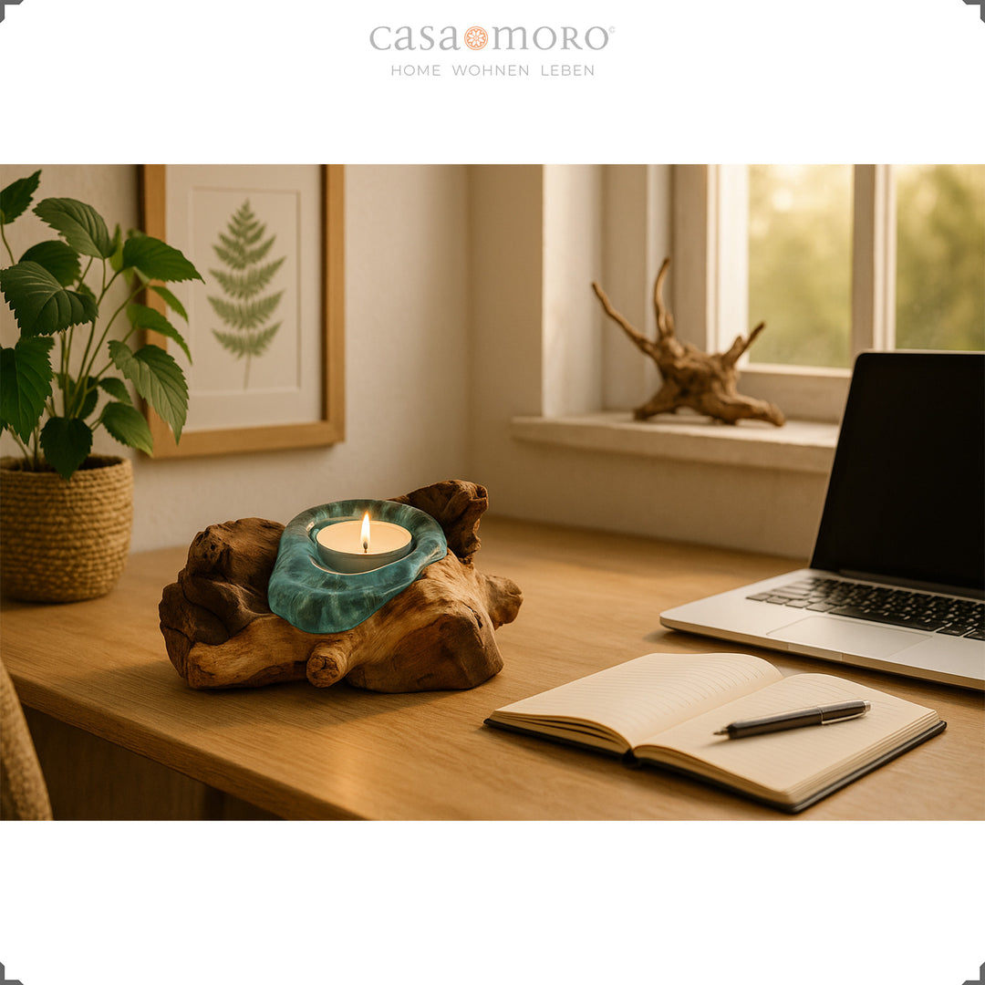 Theelichthouder van glas en wortelhout op een bureau, het zachte licht zorgt voor een natuurlijke, ontspannen werksfeer.