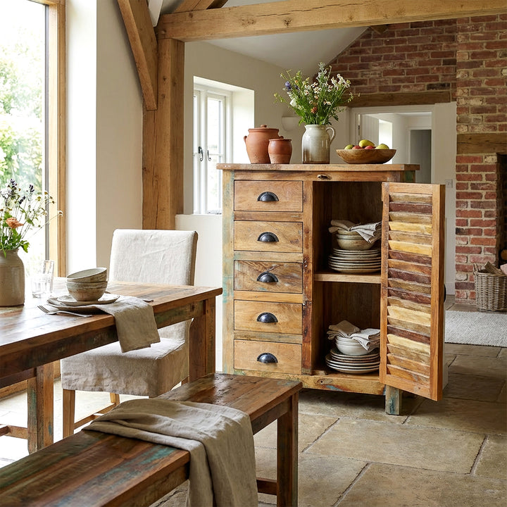 Massief houten dressoir in de eetkamer met geopende deuren, serviesgoed in het interieur, natuurlijke vintage thuisscène