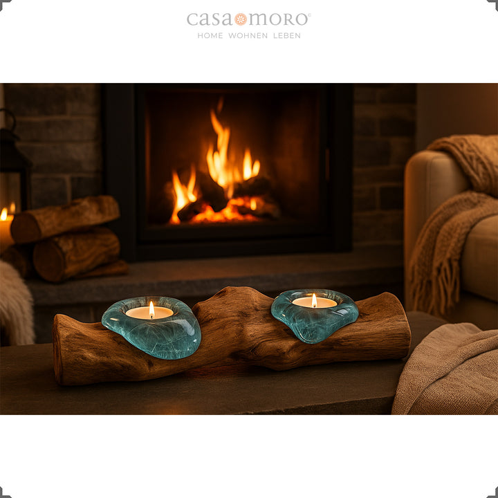 Theelichthouder van glas en wortelhout voor een open haard, het zachte licht versterkt de gezellige woonsfeer.