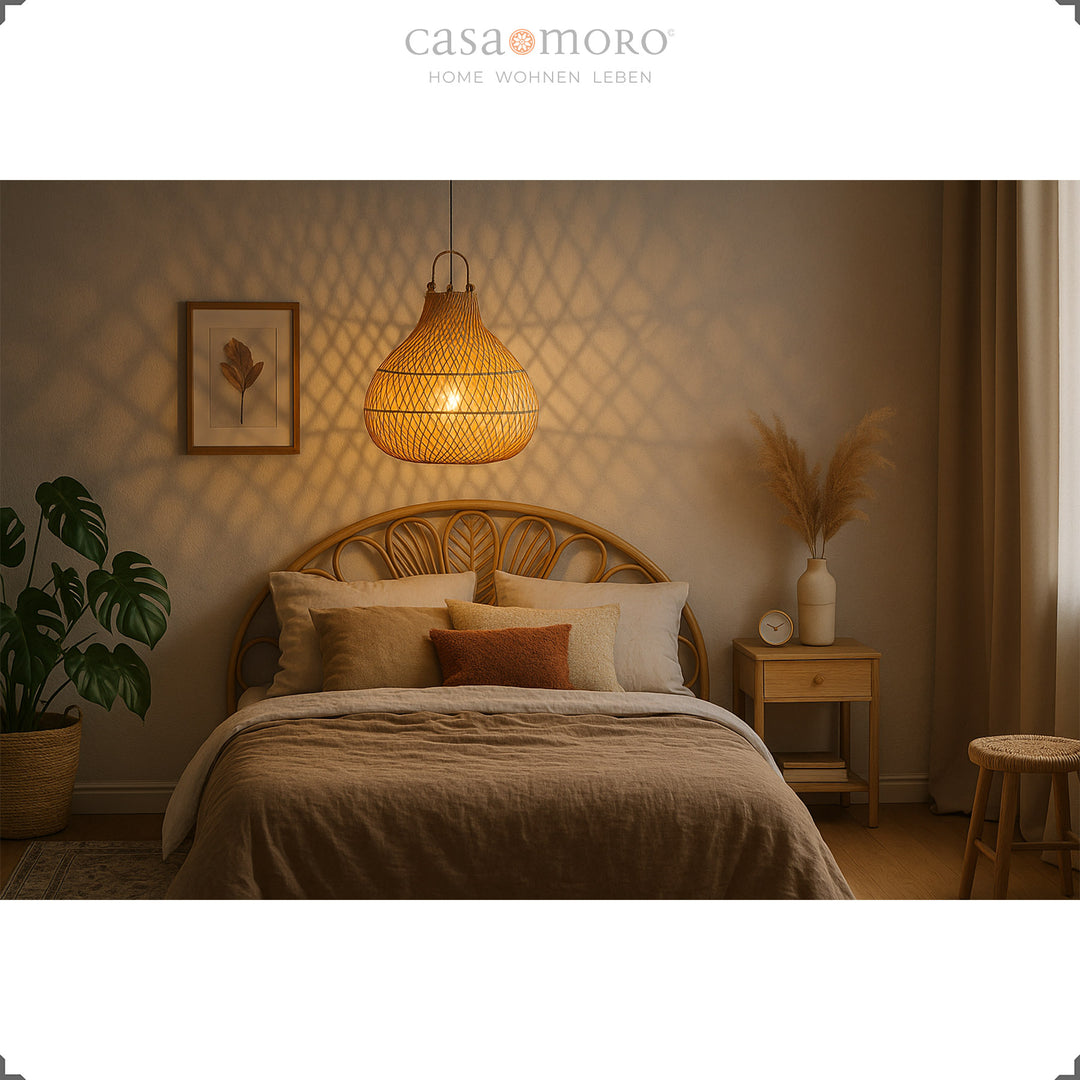 Lampe suspendue en rotin au-dessus du lit dans la chambre, lumière chaude et mobilier naturel