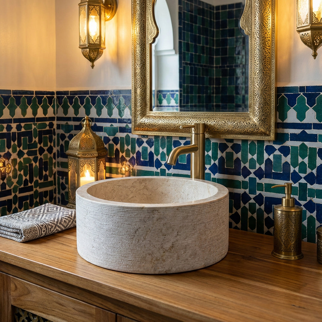 Marbre rondLavabo sur une console en bois, mise en scène de manière atmosphérique dans la salle de bains orientale avec des carreaux de mosaïque et des détails en laiton.