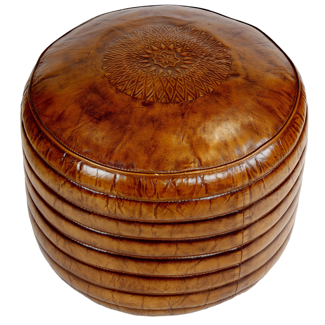 Pouf rond en cuir marron chaud avec un gaufrage de surface fin en vue rapprochée