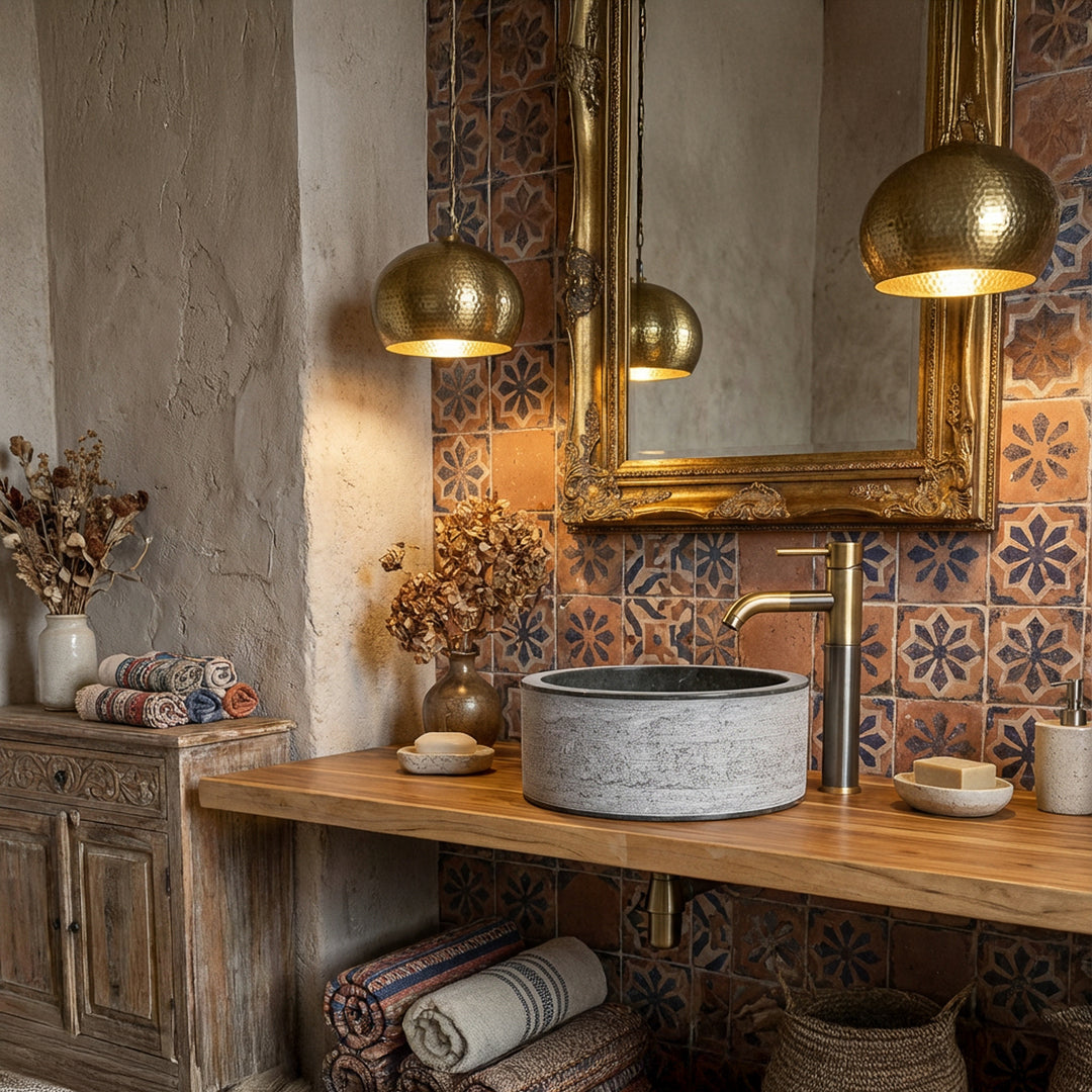 Rond Wastafel van natuursteen op een houten console, gecombineerd met messing beslag en siertegels in de oosterse badkamer.