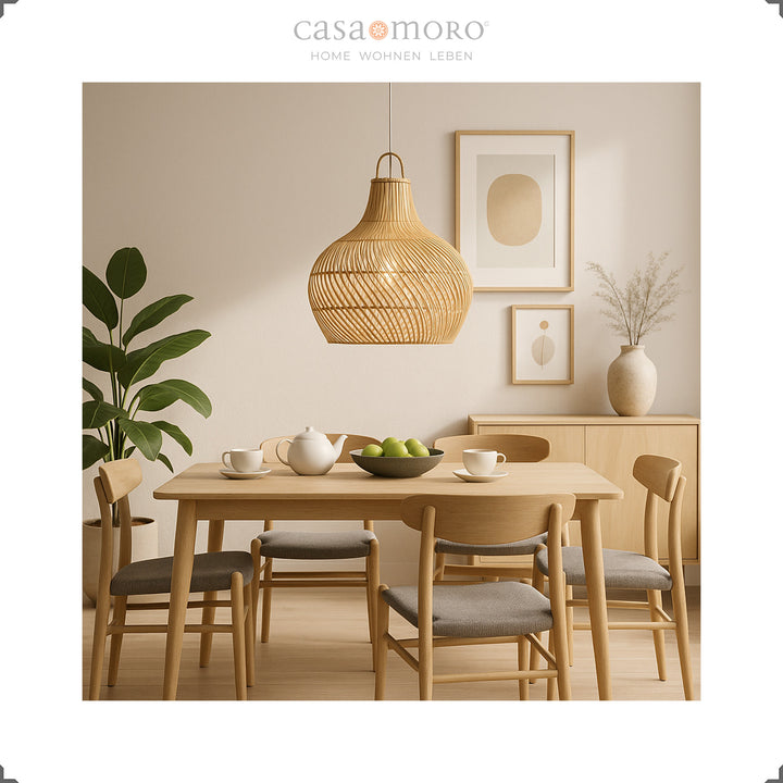 Lampe en rotin au-dessus d'une table à manger dans la salle à manger lumineuse, faite à la main et avec un doux jeu de lumière