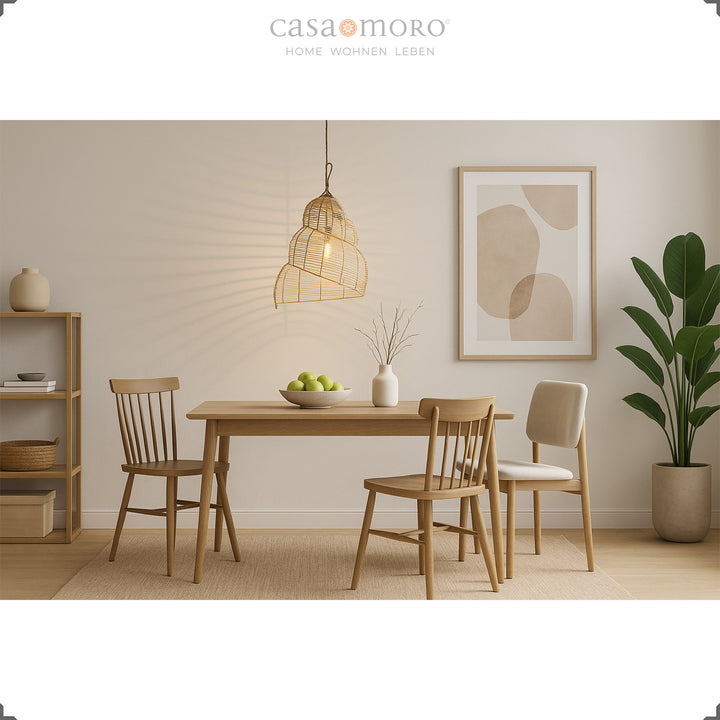 Une lampe en rotin suspendue au-dessus d'une table à manger dans la salle à manger moderne crée un jeu chaleureux d'ombre et de lumière