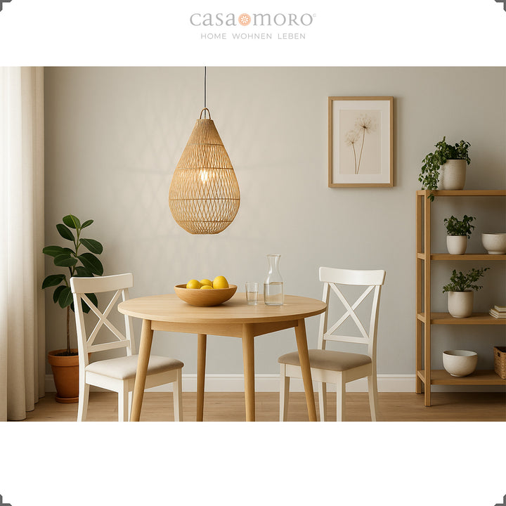 Lampe en rotin en forme de larme faite à la main au-dessus d'une table à manger, fournissant une lumière chaude et créant une atmosphère chaleureuse