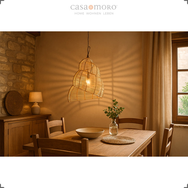 Lampe en rotin faite à la main au-dessus d'une table en bois dans la salle à manger, crée une lumière chaleureuse et une atmosphère naturelle