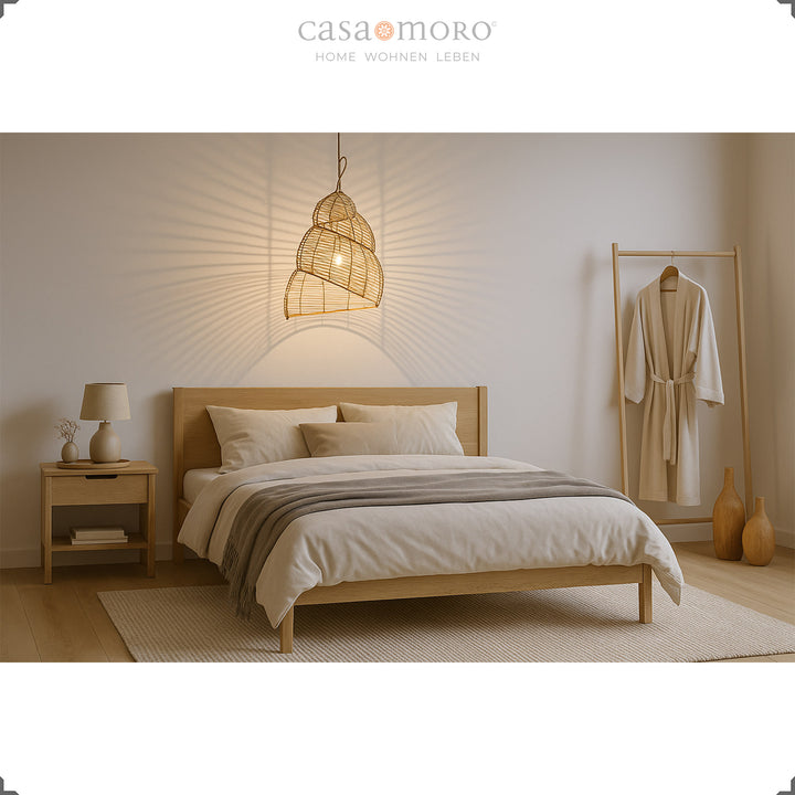 Lampe spirale en rotin comme plafonnier dans la chambre, fabriquée à la main avec un jeu d'ombre et de lumière chaleureux