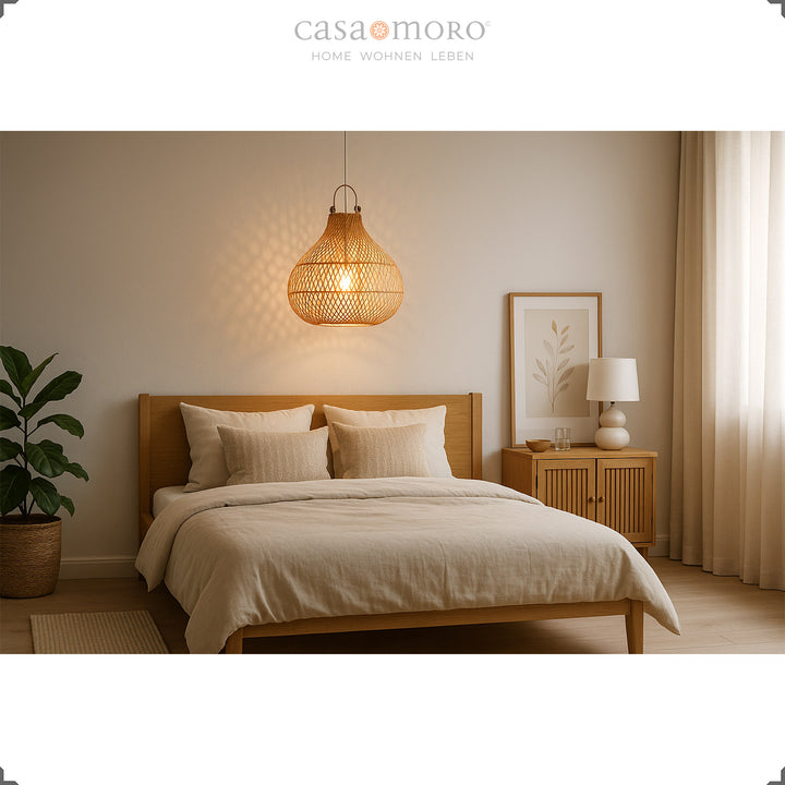 Lampe en rotin naturel au-dessus du lit dans la chambre avec lumière chaude et mobilier lumineux