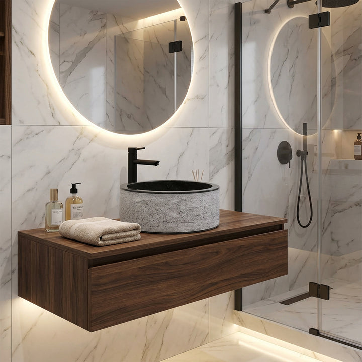 Ronde stenen wastafel op zwevende houten console, modern gecombineerd met zwart beslag in een elegante designbadkamer.