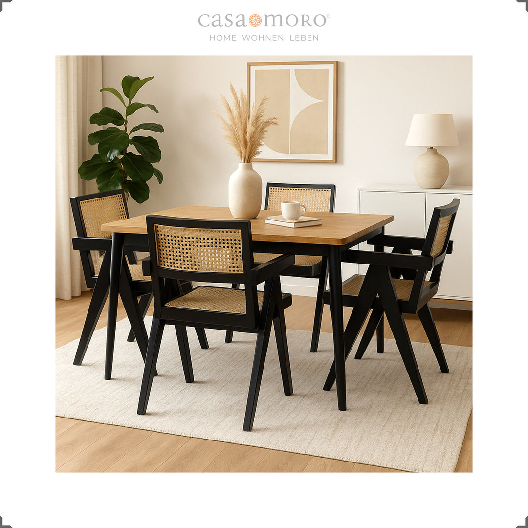 Zwarte fauteuils met Weens vlechtwerk rond een houten tafel, elegante eetkamer met warme natuurlijke tinten