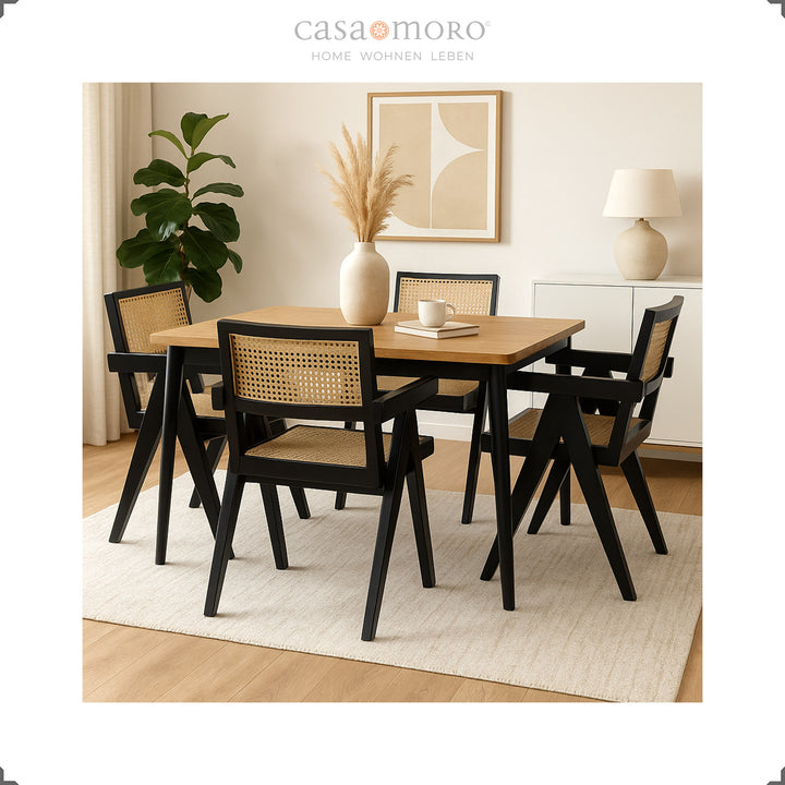 Zwarte fauteuils met Weens vlechtwerk rond een houten tafel, elegante eetkamer met warme natuurlijke tinten