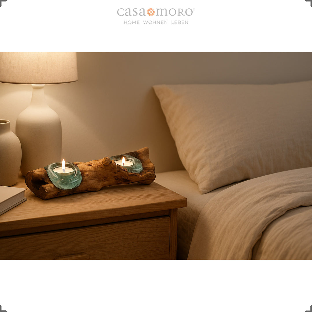 Langwerpige theelichthouder van glas en wortelnotenhout op een nachtkastje, het zachte licht zorgt voor een rustgevende slaapkamersfeer.
