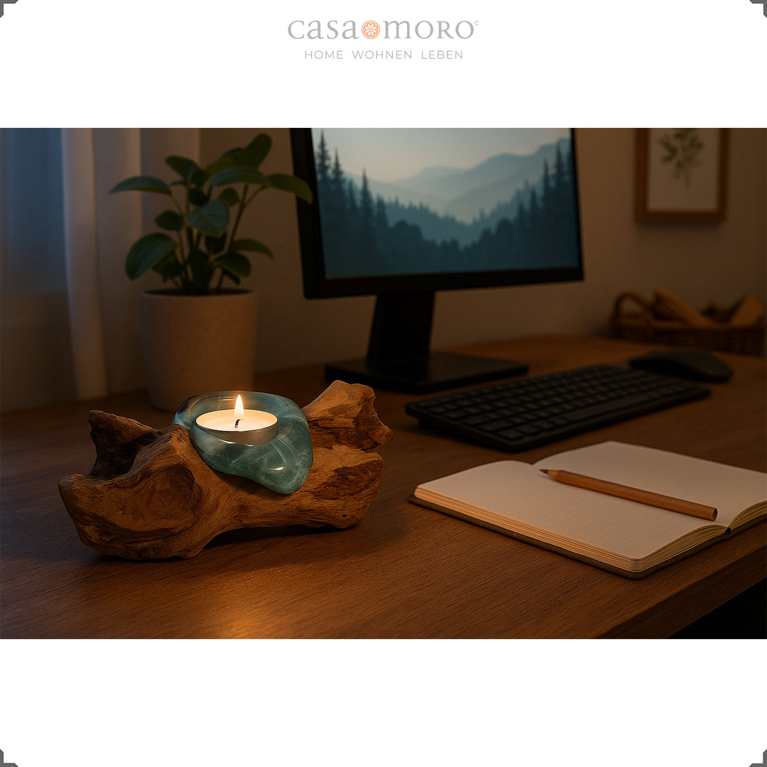 Theelichthouder van glas en wortelhout op een bureau, het warme licht zorgt voor een ontspannen, geconcentreerde werksfeer.