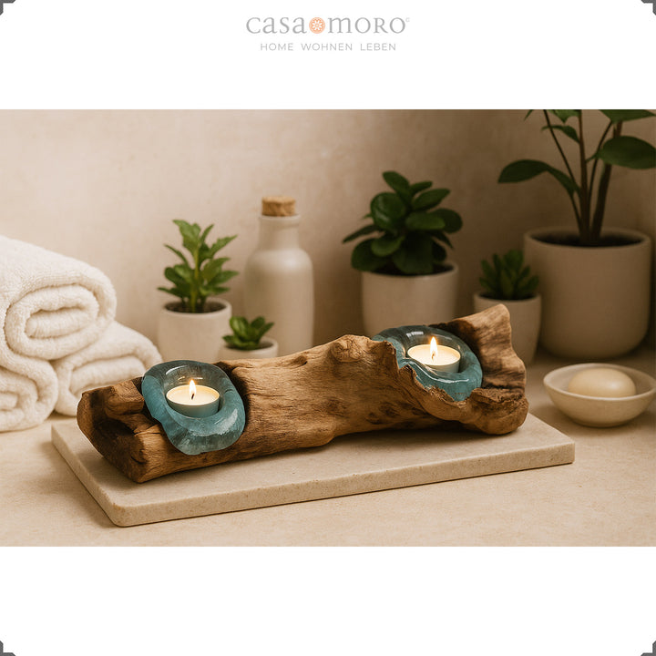 2 theelichthouders van glas en wortelhout in de badkamer, het zachte licht complementeert de ontspannen spa-sfeer met planten en handdoeken.