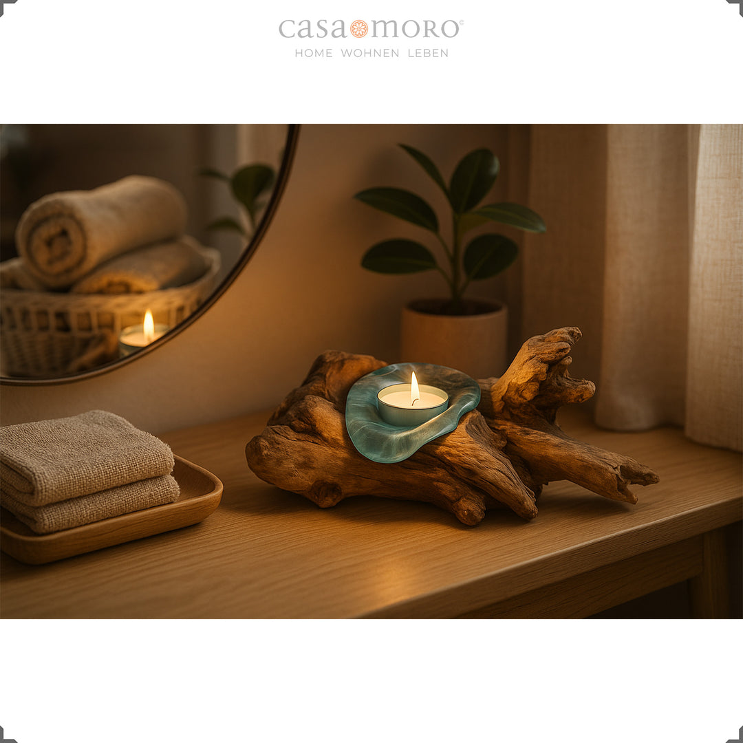 Theelichthouder van glas en wortelhout op een console, het warme kaarslicht zorgt voor een zachte, huiselijke sfeer.