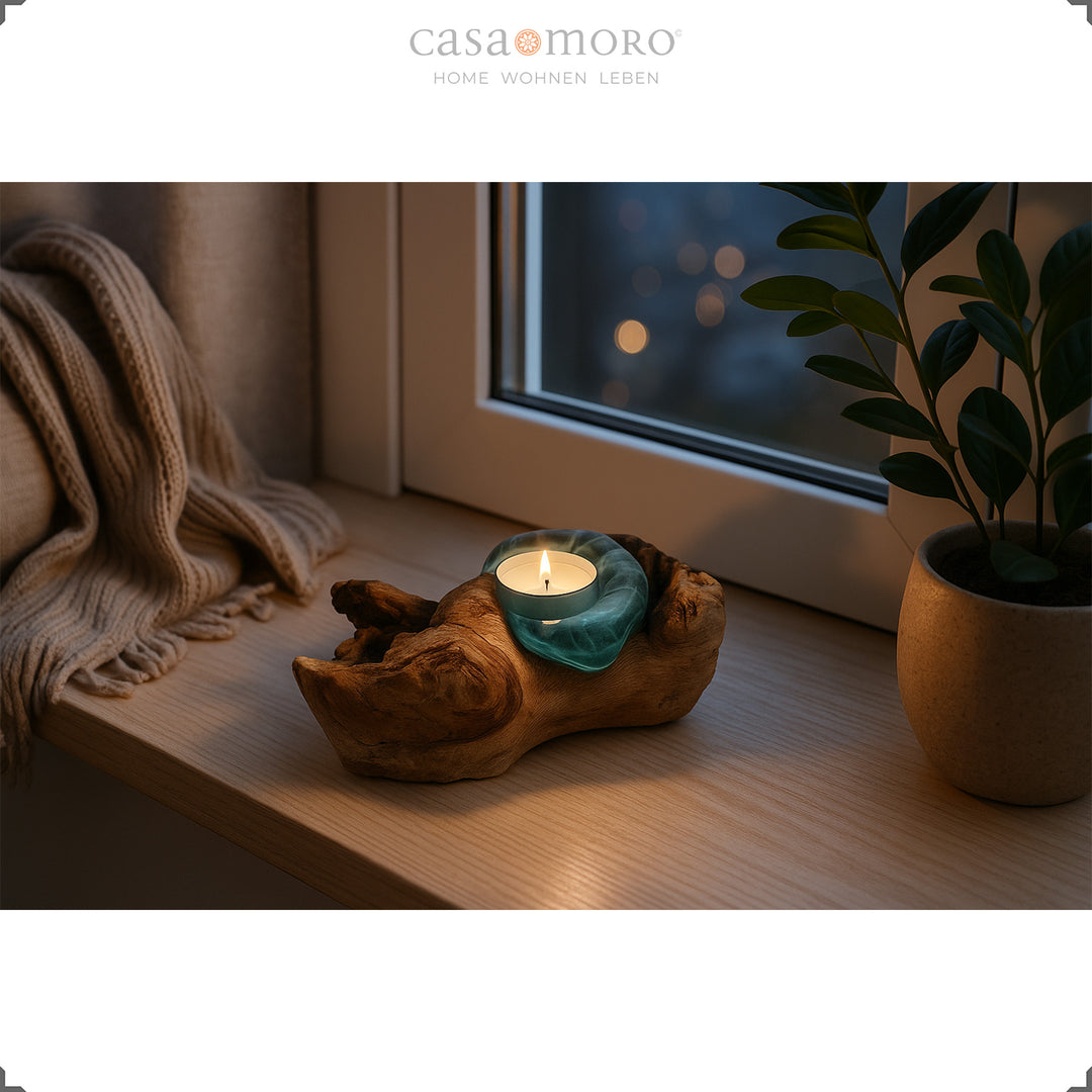 Theelichthouder van glas en wortelhout op een vensterbank, het zachte licht zorgt 's avonds voor een rustige, rustgevende sfeer.