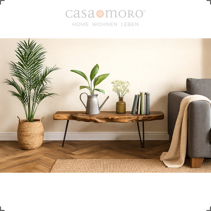  Houten teakhouten tafel in woonkamersfeer met plantendecoraties, tapijt en bank