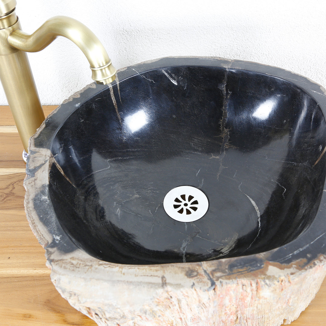 Stenen spoelbak van versteend hout met donker gepolijst binnenoppervlak, bovenaanzicht met afvoer en messing beslag op houten blad.