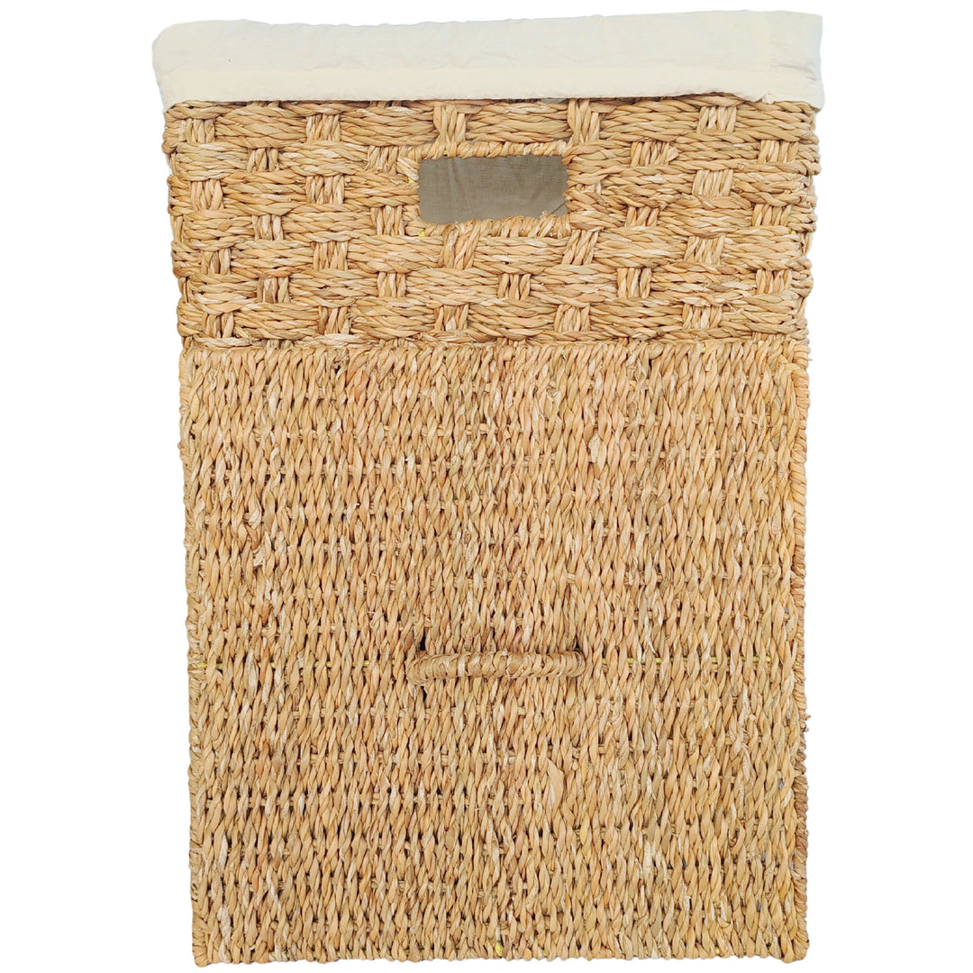 Panier à linge carré en jonc de mer, bord de sac clair et couvercle rectangulaire tressé dressé devant.