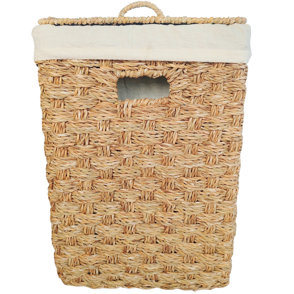Panier à linge carré en jonc de mer vu de face, couvercle fermé, bord de sac clair et ouverture de prise.