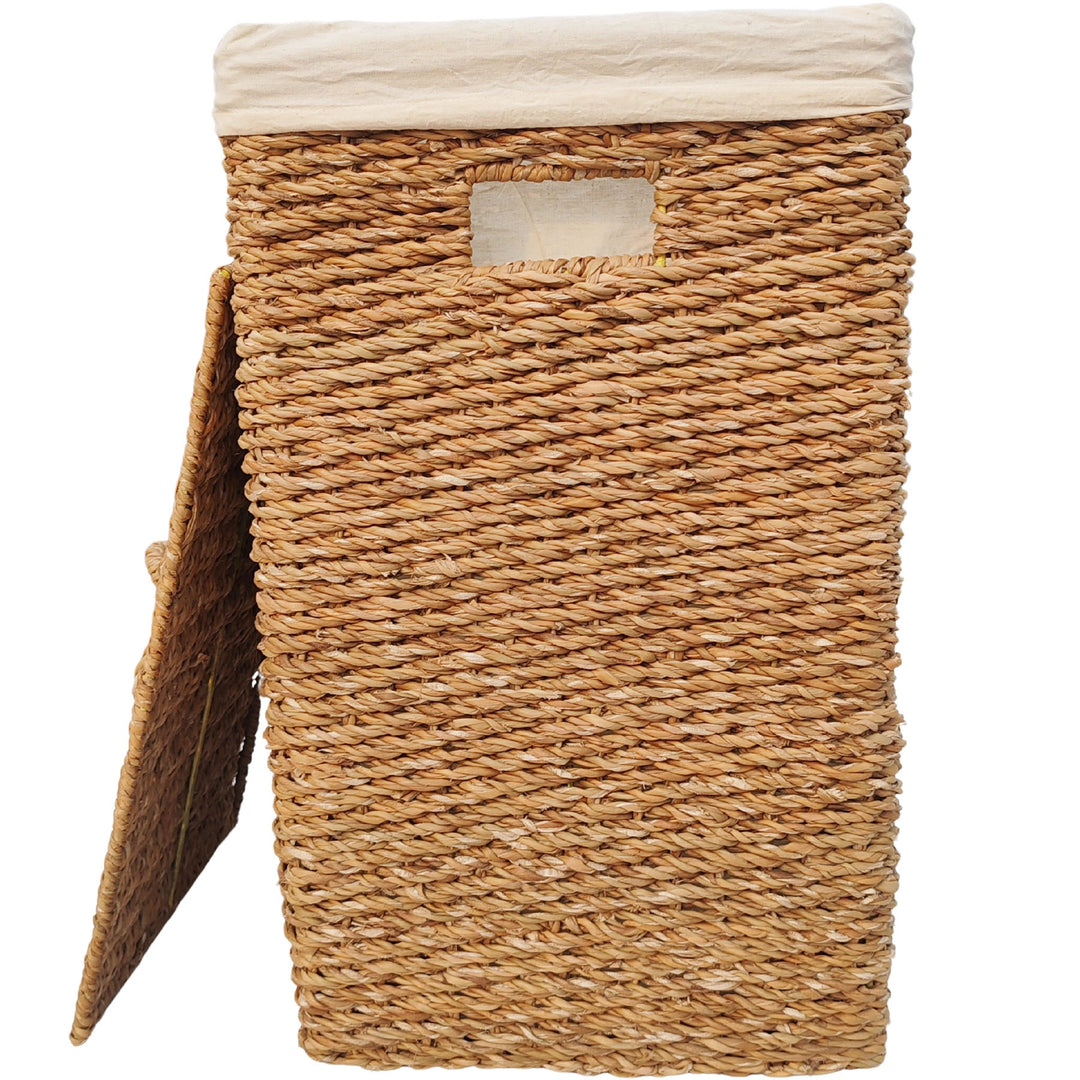 Panier à linge rectangulaire en jonc de mer d'une capacité de 90 litres, doté d'un insert en tissu clair et d'un couvercle s'appuyant sur le côté.
